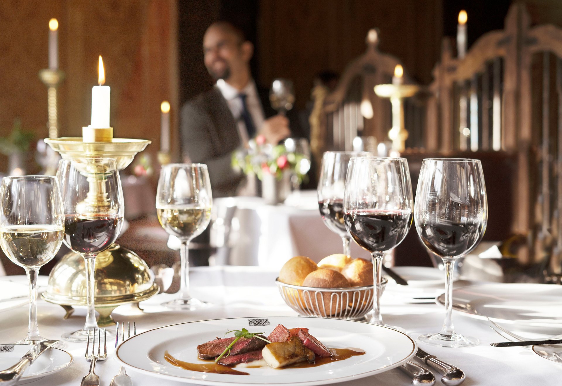 A table laid with wine glasses and a dish of duck under the Witchery’s brass candlesticks