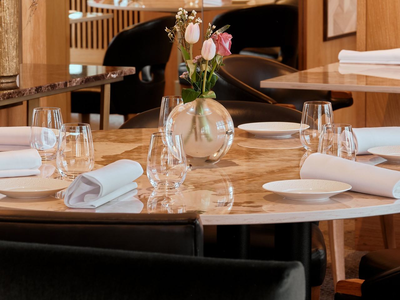 Tables laid with marble tops and fresh flowers in the dining room of Restaurant Martin Wishart in Leith